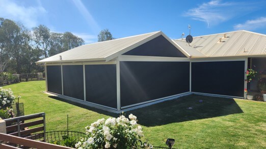 Outdoor blinds installed on a large patio enclosed area in a residential backyard