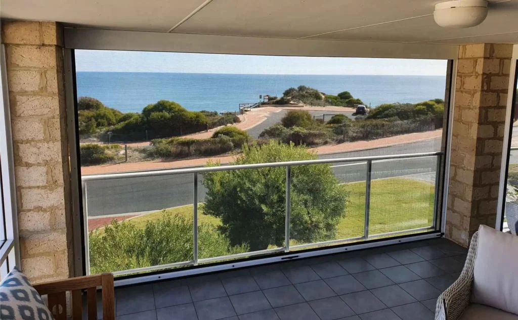 Outdoor blinds doing well in a windy setting by the beach, demonstrating strength and durability