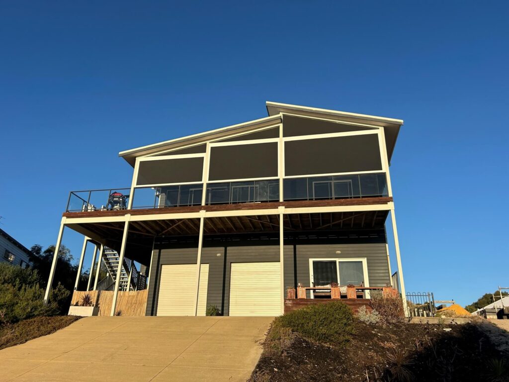 treet view of a two storey home with eZIP outdoor blinds covering the upper balcony