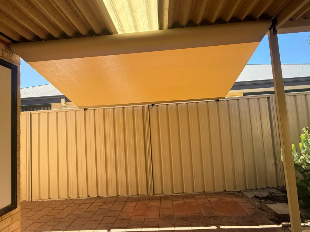 Roof to fence blind in Paperbark mesh shading a paved courtyard in Landsdale