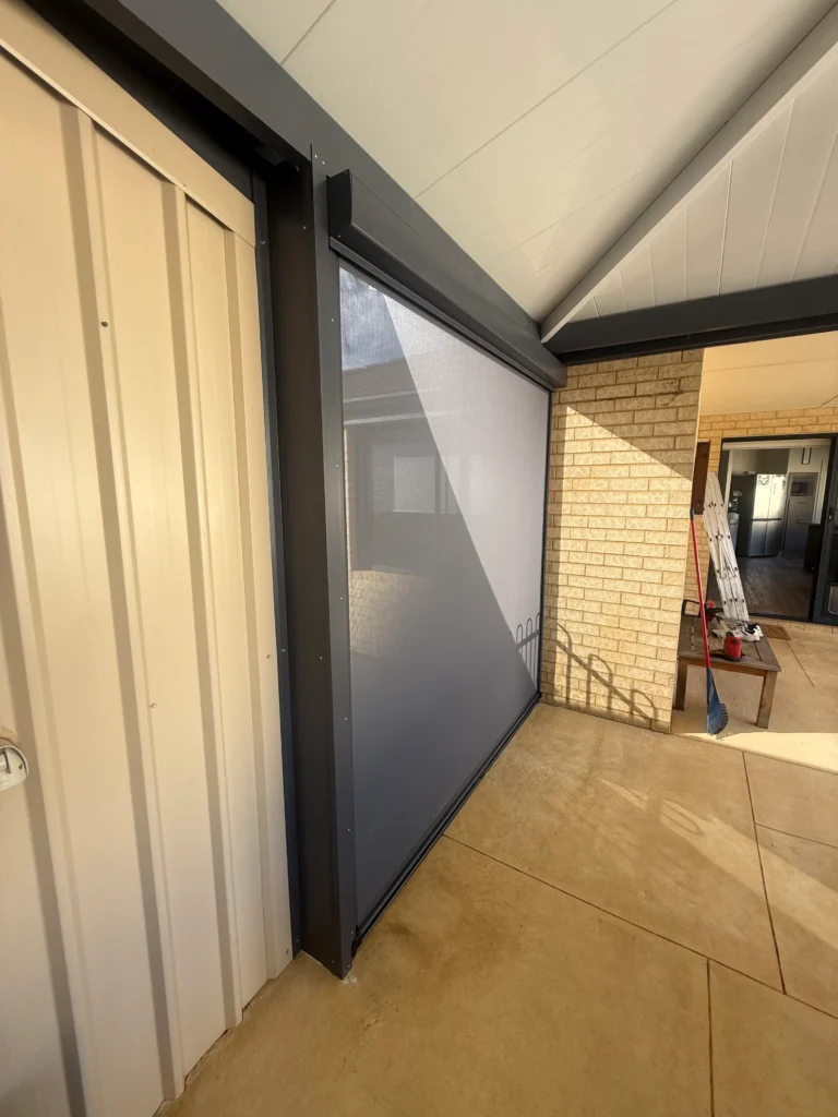 Ziptrak outdoor blind in Ironstone mesh fitted between a shed wall and the house in Forrestfield