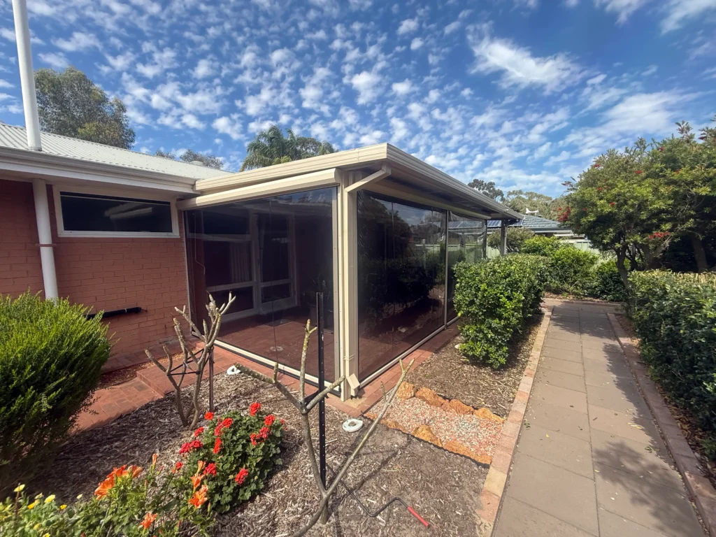 Exterior view of a Rivervale patio closed in with tinted PVC Ziptrak blinds