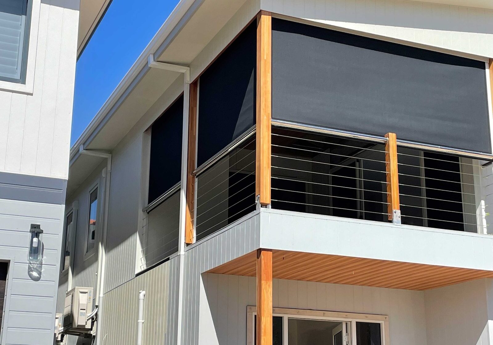 Charcoal Vistaweave mesh balcony blind on an architectural balcony exterior