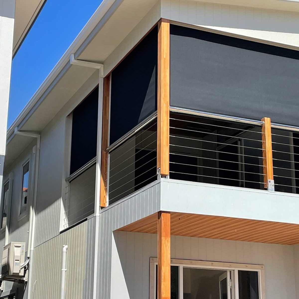 Charcoal Vistaweave mesh balcony blind on an architectural balcony exterior