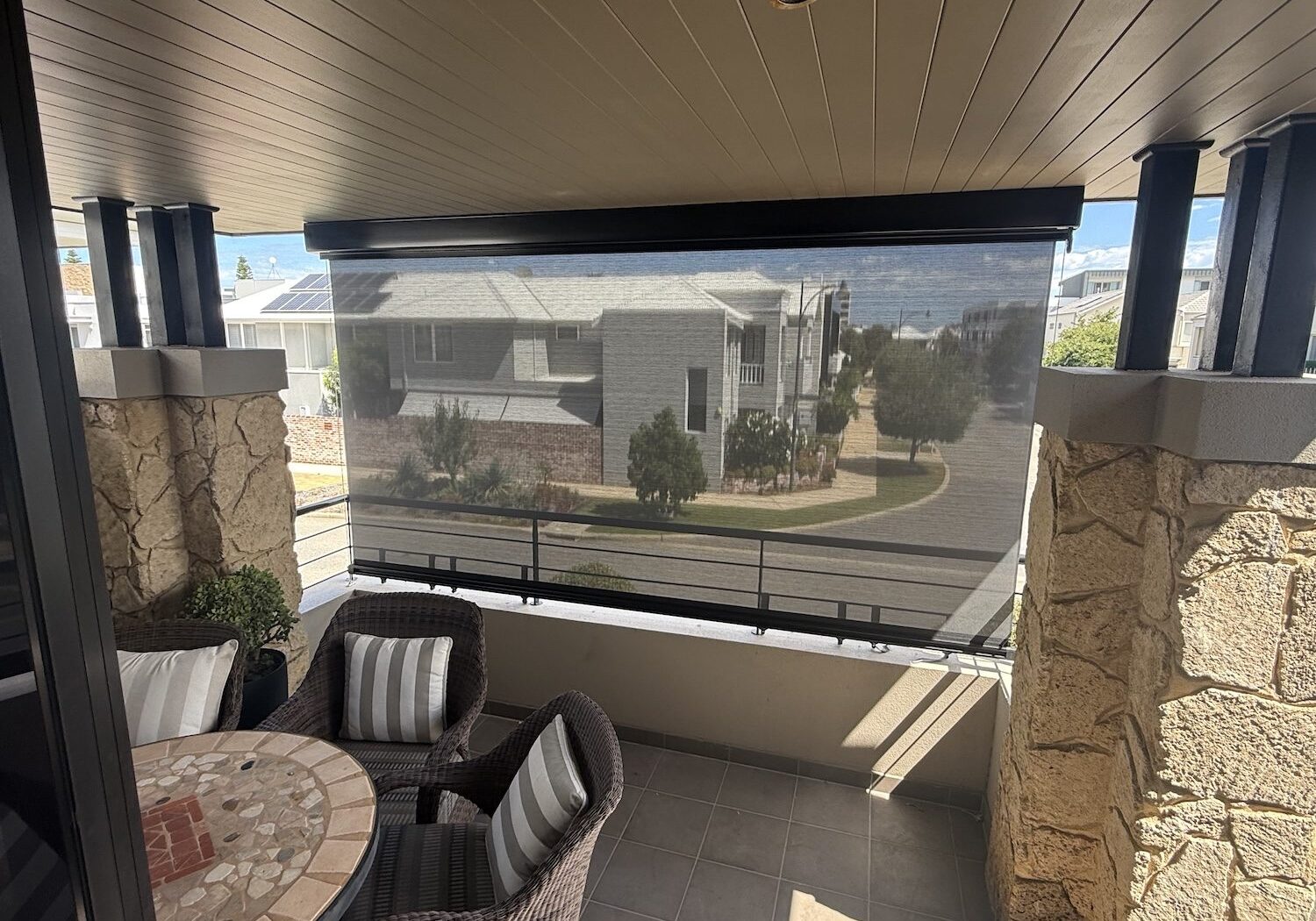 Alfresco balcony with a cable guided blind creating a sheltered outdoor living area