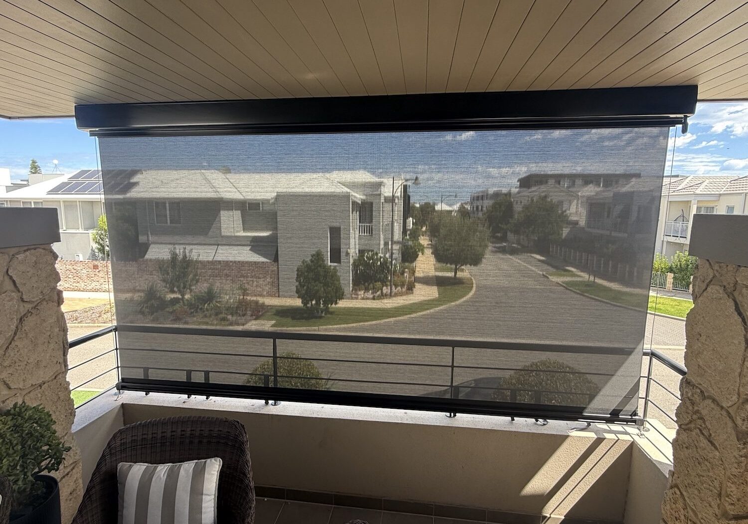 View through a cable guided mesh blind from a covered balcony