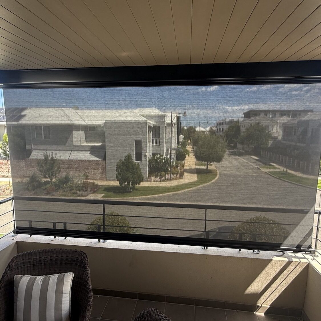 View through a cable guided mesh blind from a covered balcony
