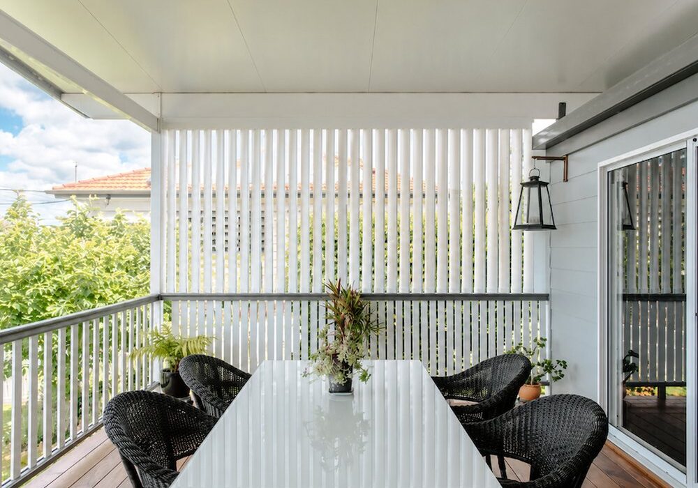 White vertical outdoor shutters on a patio dining area